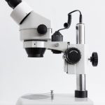 white and black microscope on white surface