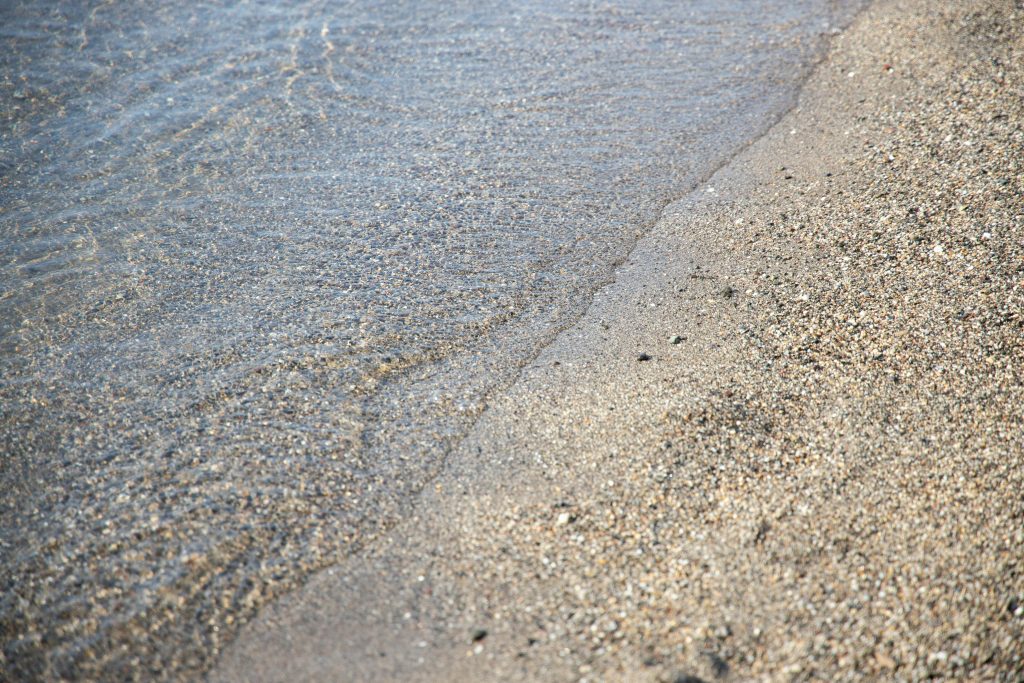Close-up of a tranquil beach with gentle waves lapping at the sandy shore.